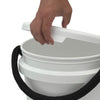 A hand removes the Shurhold Industries, Inc. Bucket Lid from a white plastic bucket with a black rope handle using the ergonomic release tab for easy opening.