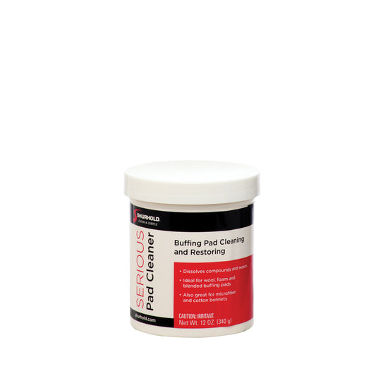 A white 12 oz plastic container labeled Serious Pad Cleaner by Shurhold Industries, Inc.—a citrus-based cleaner for buffing pads with product details and cautions on the label, ideal for cleaning, restoring pads, and removing mold and mildew stains.