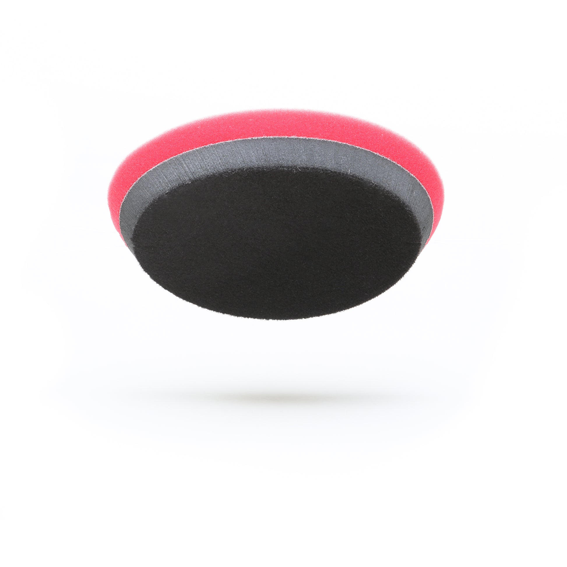 The Pro Polish Pad for DAP PRO by Shurhold Industries, Inc. is a 7 round, two-tone foam pad (red top, black bottom) ideal for polishing and waxing with the Shurhold Dual Action Polisher PRO; shown floating against a white background.
