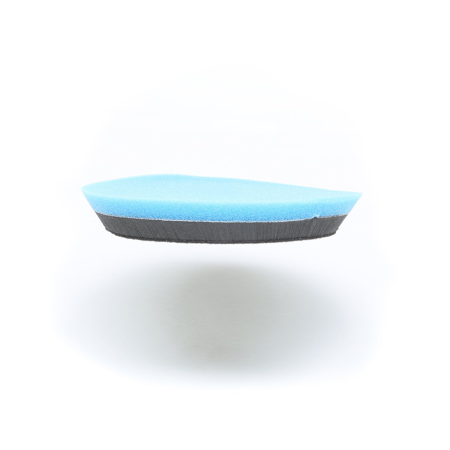 A blue and black foam cleaning sponge, the Buff Magic Heavy Oxidation Pad by Shurhold Industries, Inc., is shown isolated on a white background with a faint shadow beneath.