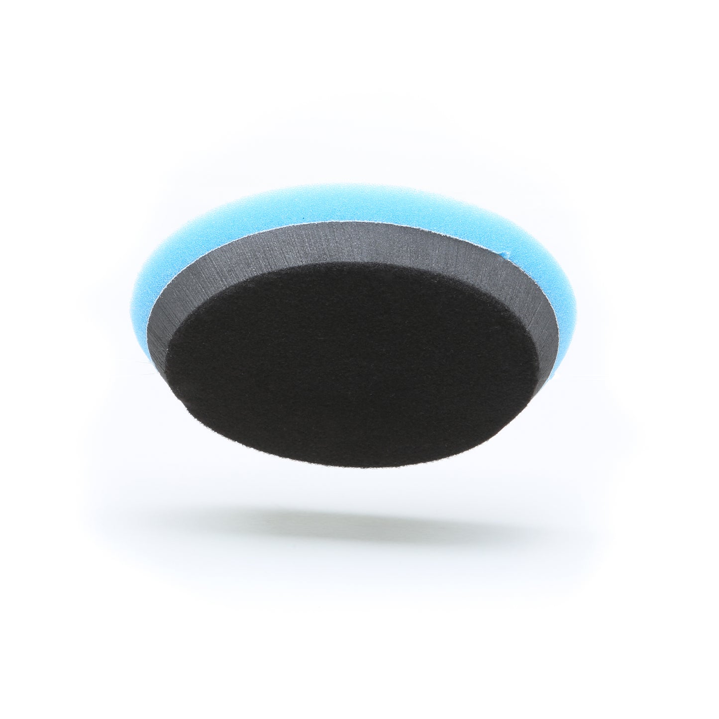 The Buff Magic Heavy Oxidation Pad from Shurhold Industries, Inc. is a round cleaning sponge with a blue edge and black scrubbing surface, ideal for tackling severe oxidation with the Dual Action Polisher PRO, shown on a white background.