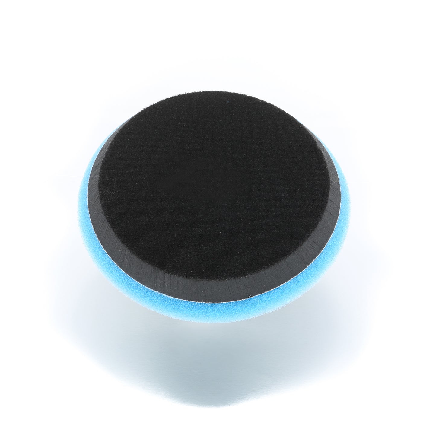 A round, black Buff Magic Heavy Oxidation Pad by Shurhold Industries, Inc., featuring a blue edge for the Dual Action Polisher PRO, is shown against a white background—perfect for removing severe oxidation.