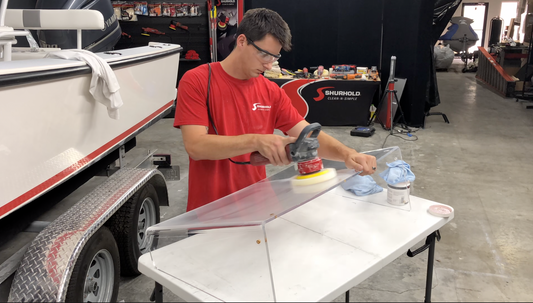 Man buffing plexiglass windshield 