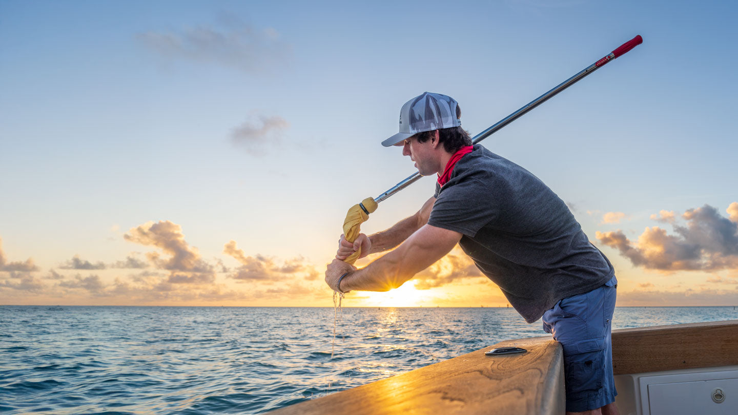 man squeezing out shurhold mop on boat